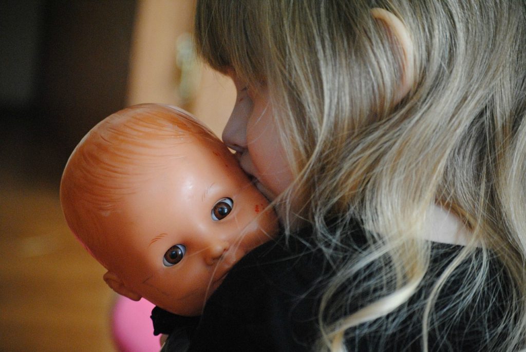 Mädchen mit Puppe teilen bei Kindern