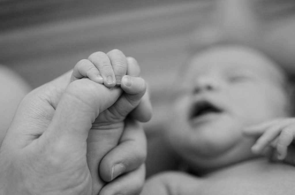 Mutter hält Baby Hand Perspektivenübernahme