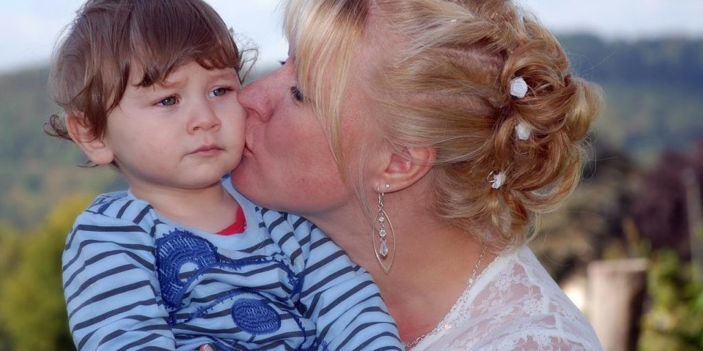 Mutter küsst Kind auf die Wange Gleichaltrigenorientierung Neufeld